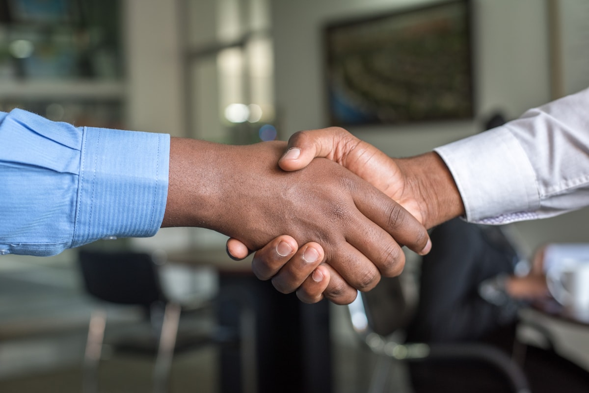 Duas pessoas apertando as mãos após uma reunião de negócios